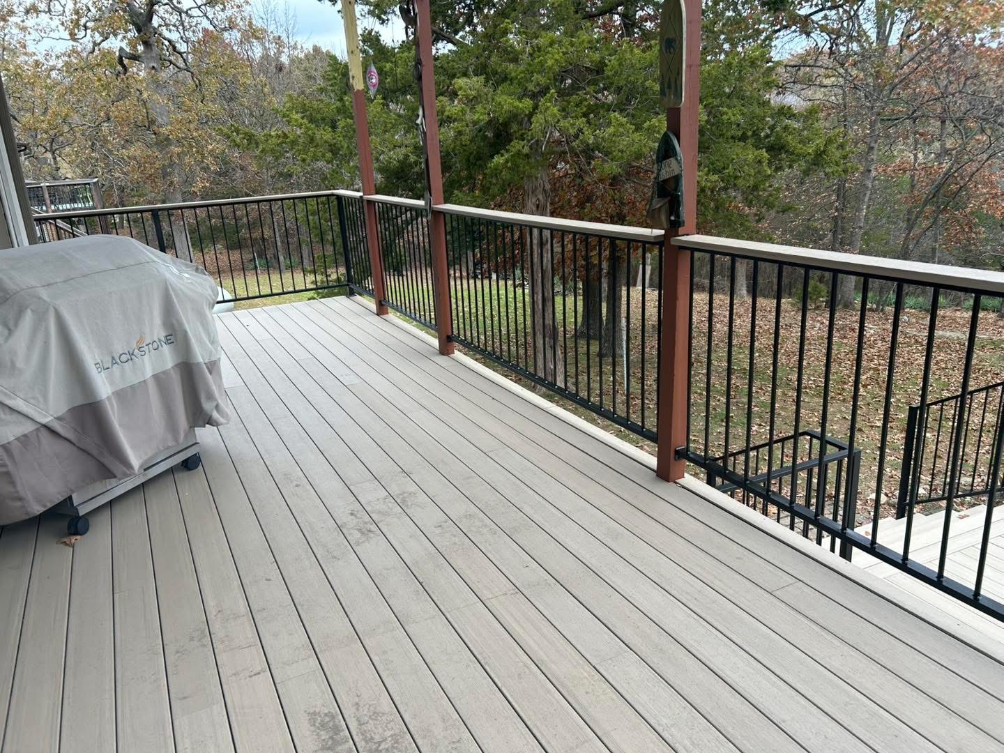 Composite deck with black aluminum picket railing and outdoor grill