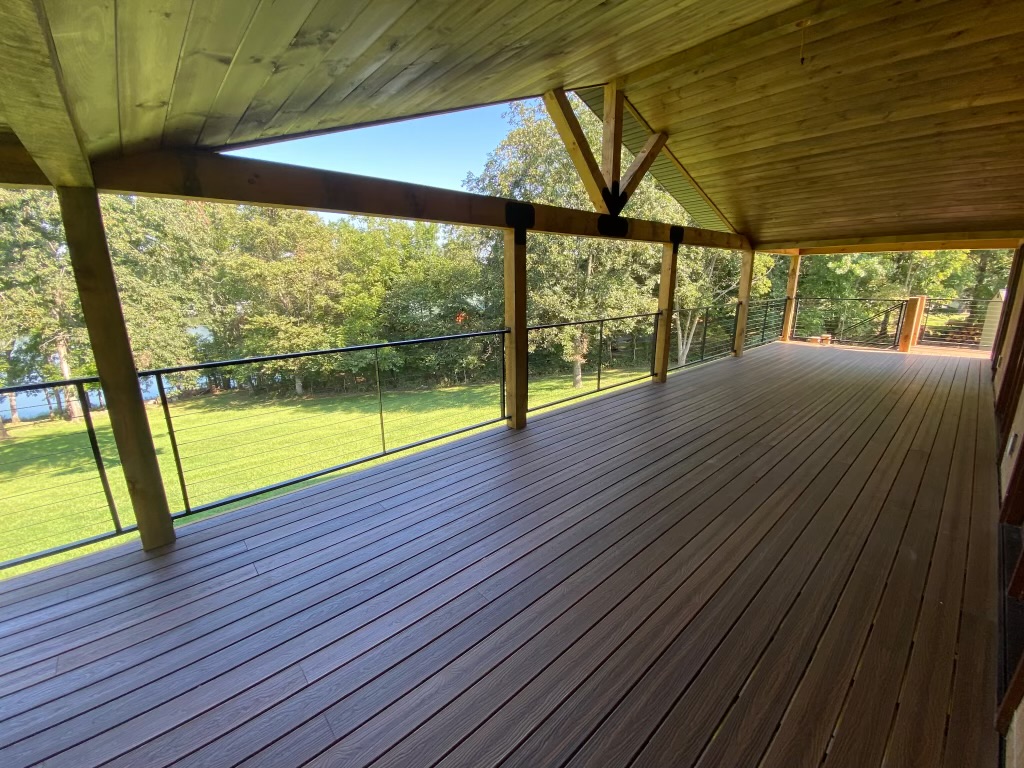 Large covered composite deck with heavy timber framing and cable railing