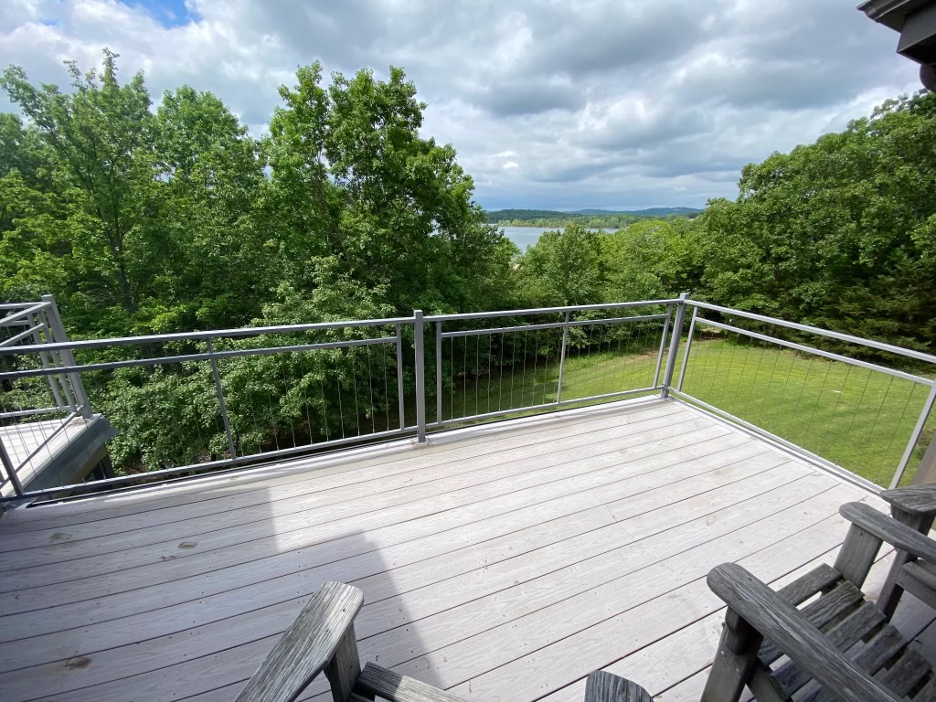 Brushed aluminum cable railing on a wood deck with lake view